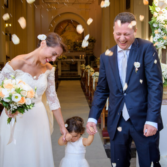 Matrimoni, sposi con figlioletta accolti dalla pioggia di petali all'uscita della chiesa